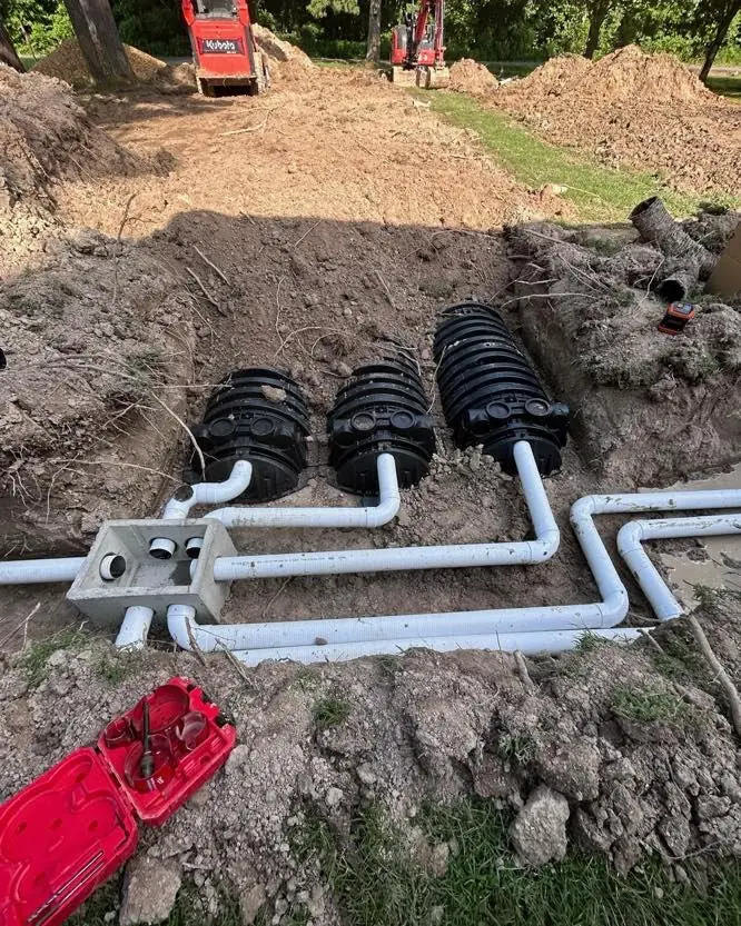 Drain field chambers connected to white distribution pipes