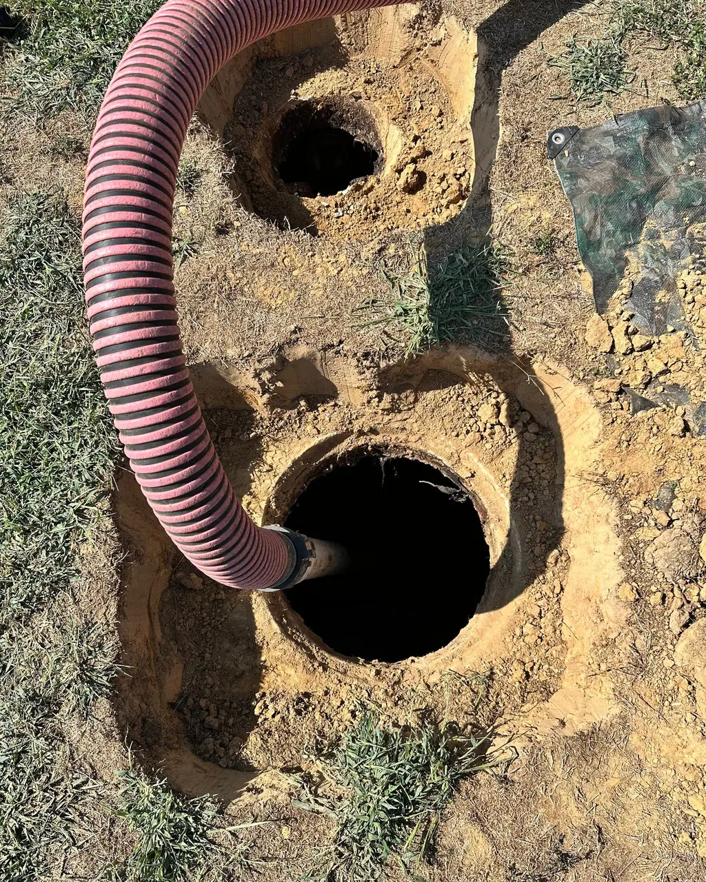 The Wurth Brothers pump hose running into an open septic tank