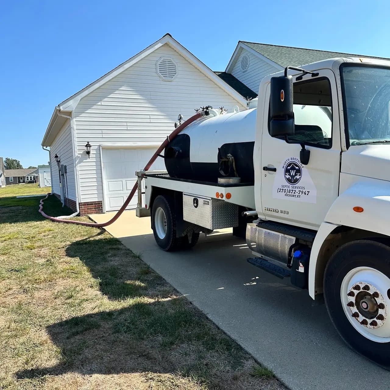A Wurth Brothers truck pumping a septic tank at a home.